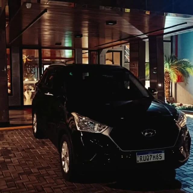 Carro da Transfer YS em frente a um hotel à noite