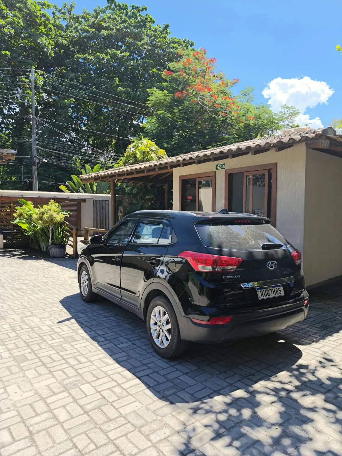 SUV da Transfer YS estacionado no acesso de uma hospedagem durante o dia